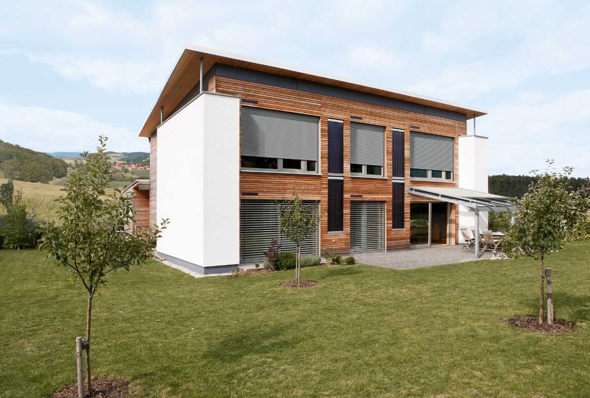 Modernes Holzhaus mit großen Fenstern in einer ländlichen Umgebung